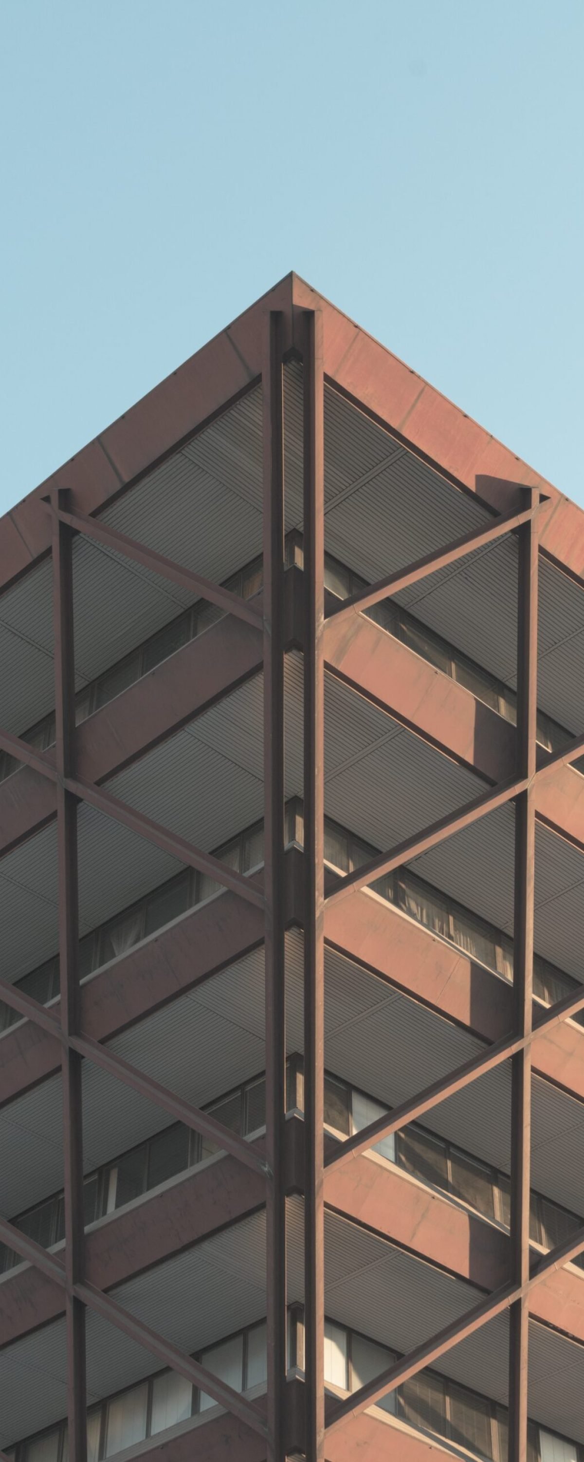 A low angle shot of a modern building in the middle of the city under the clear sky