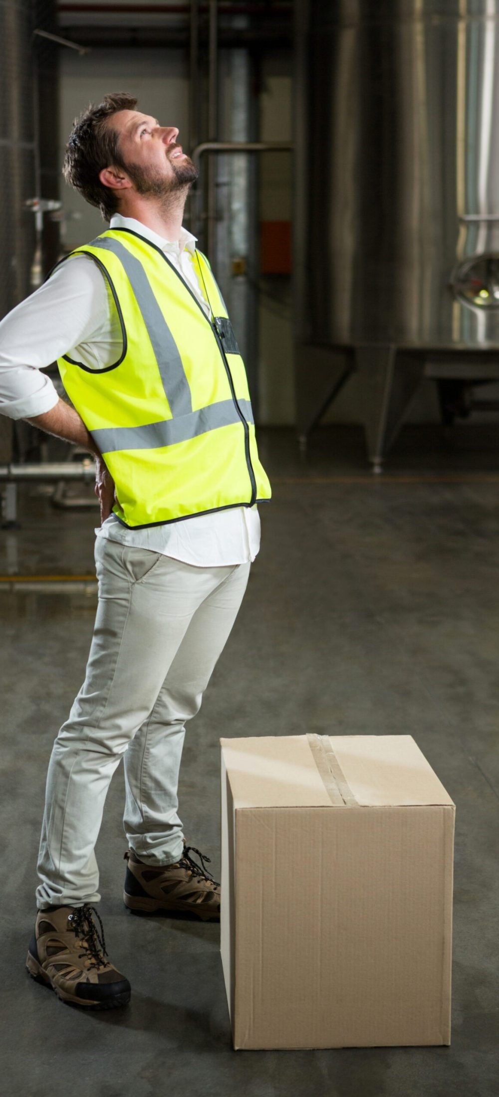 Full length of tired male worker standing in warehouse